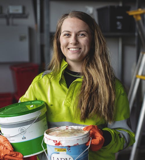 Fagansvarlig for farlig avfall på Årabrot miljøpark, Eivor Ytreland, er avbildet med to tomme malingspann