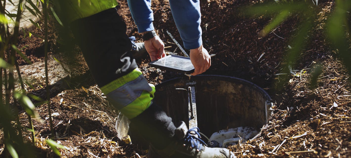 En person tømmer en slam-tank