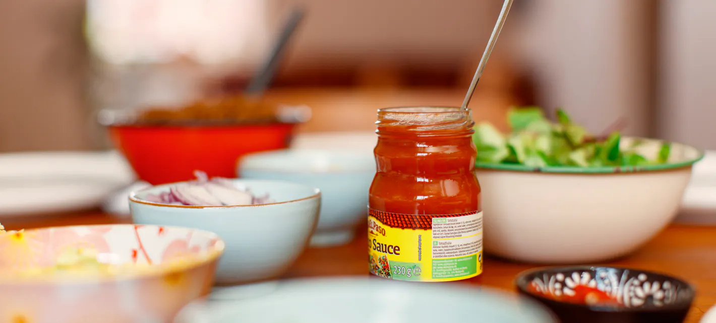 Forskjellige skåler og glass med tacotilbehør på et spisebord