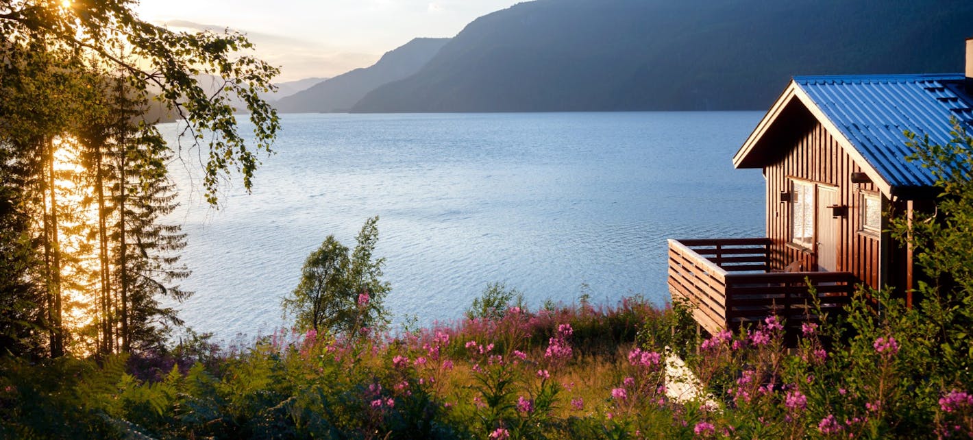 Bilde av hytte som ligger ved en fjord