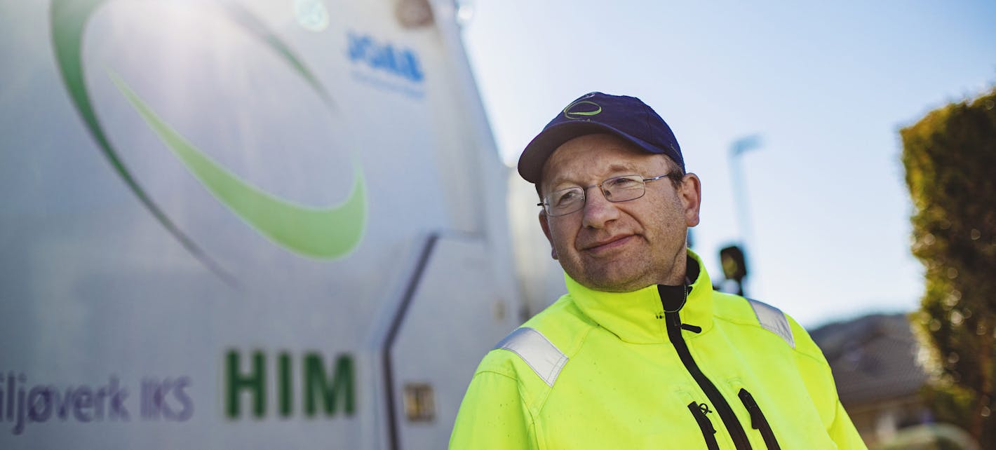 Renovatør Sigvald Thorsen avbildet foran en renovasjonsbil