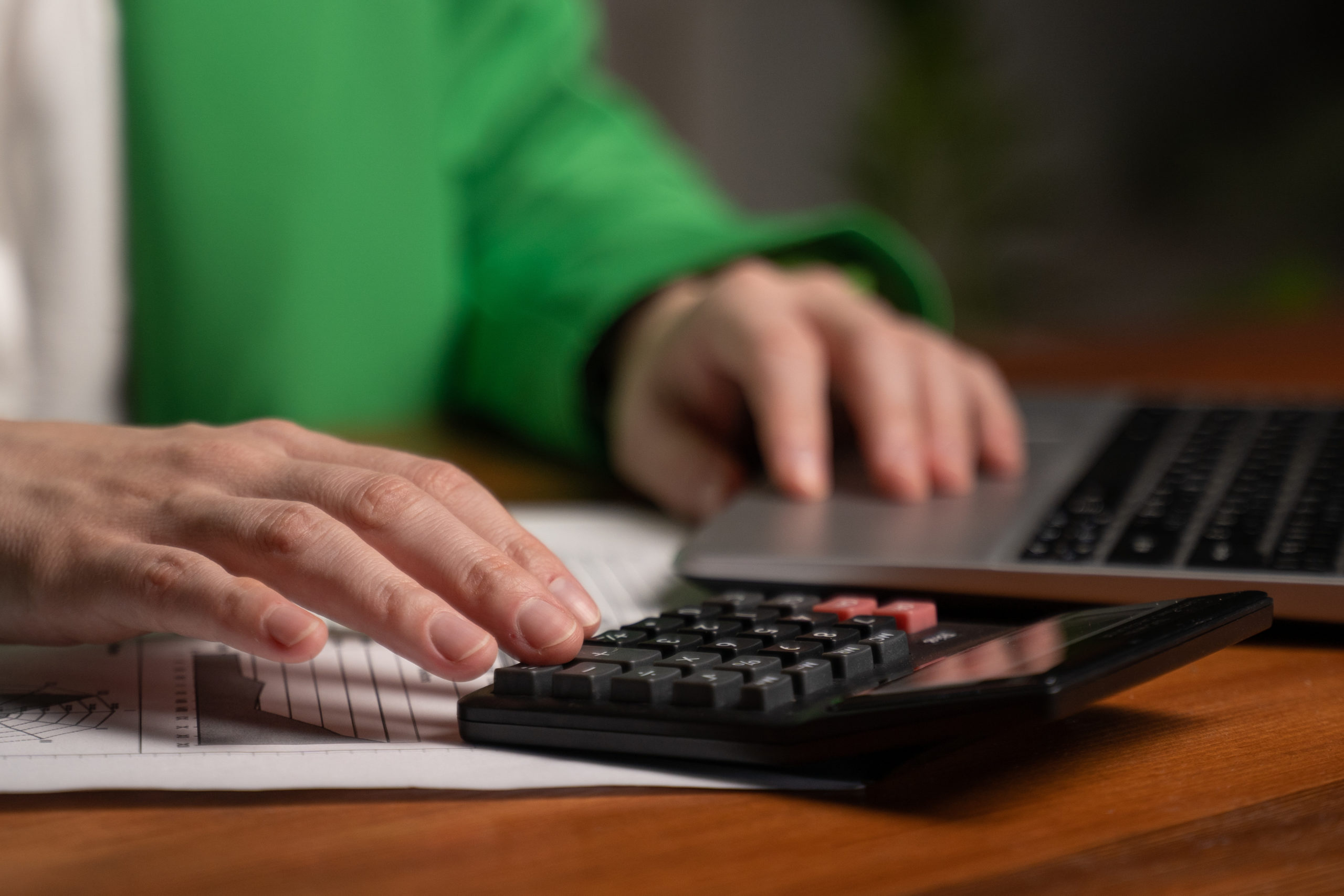 To hender som jobber på en kalkulator og et tastatur