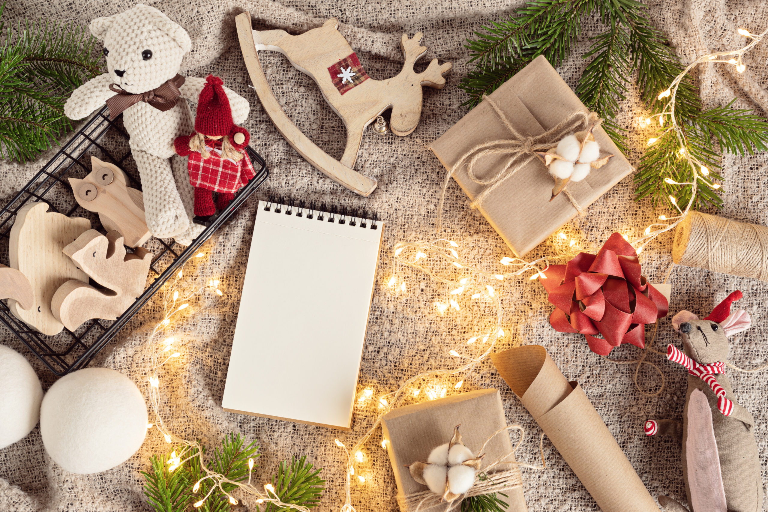 Bilde av julepynt og gaver i naturmaterialer, granbar og en lyslenke