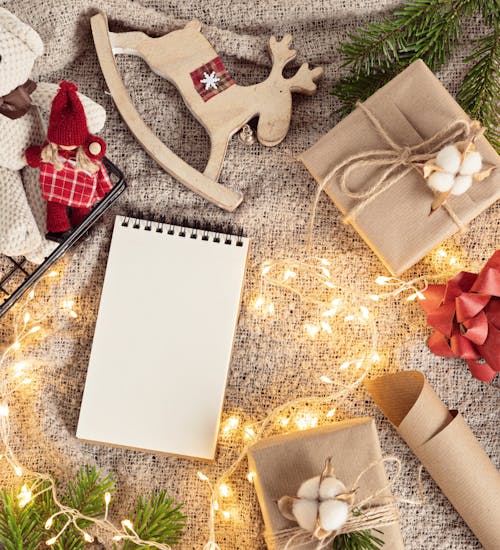 Bilde av julepynt og gaver i naturmaterialer, granbar og en lyslenke