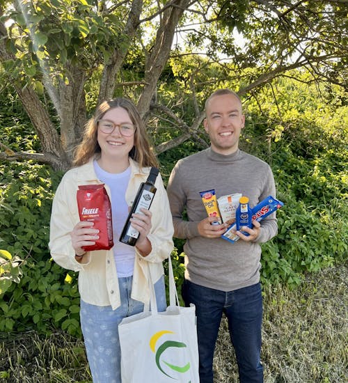 Studentene Caroline og Georg med eksempel på gavepose som gis til HIM-kunder som melder seg på hjemmebesøk