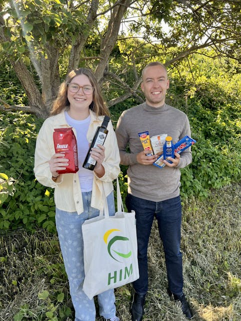 Studentene Caroline og Georg med eksempel på gavepose som gis til HIM-kunder som melder seg på hjemmebesøk