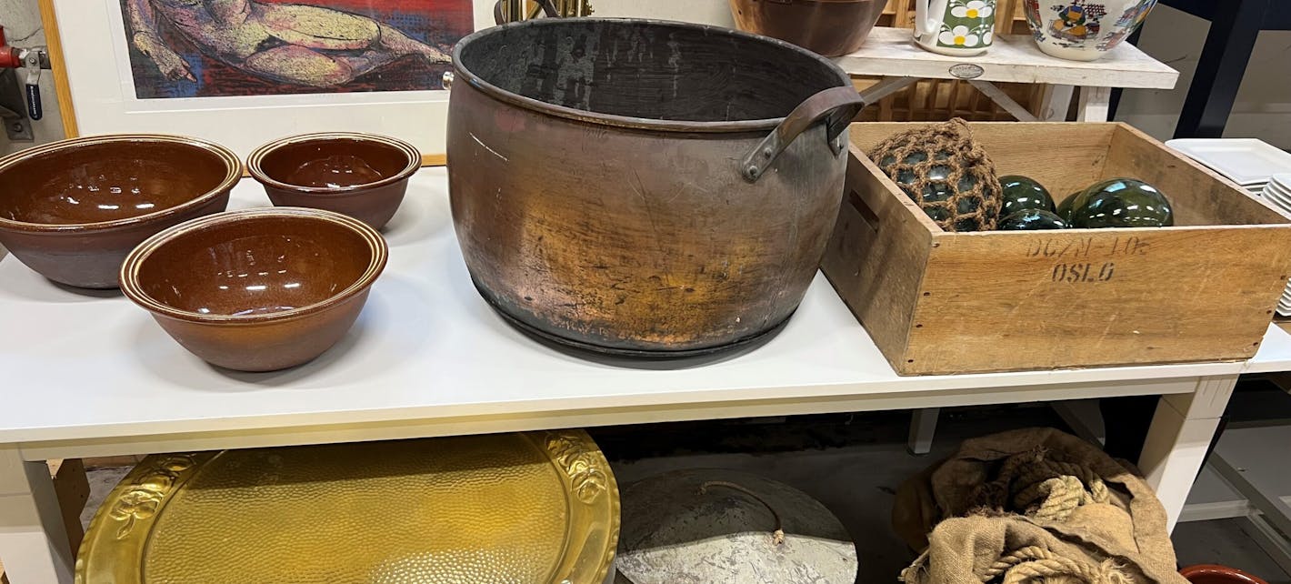 Ulike varer som selges på auksjonen, som en kobberbalje, garnkuler, bakeboller i brun keramikk og gammelt tauverk.