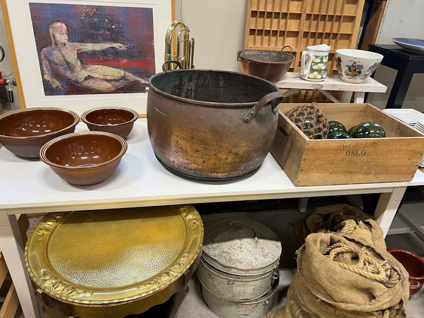 Ulike varer som selges på auksjonen, som en kobberbalje, garnkuler, bakeboller i brun keramikk og gammelt tauverk.