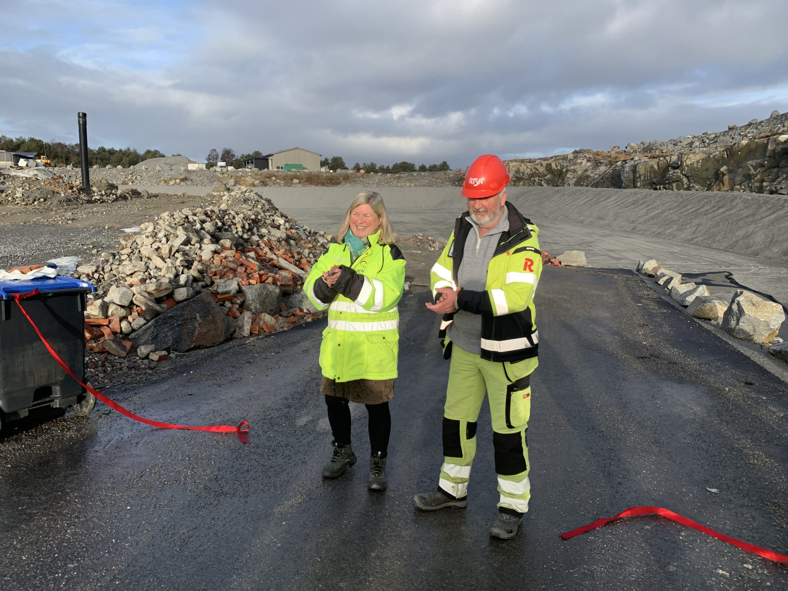 Bilde av Gro Staveland i HIM og Øyvind Stange fra Risa. De står ved en avklippet rød snor foran det nye deponiet.