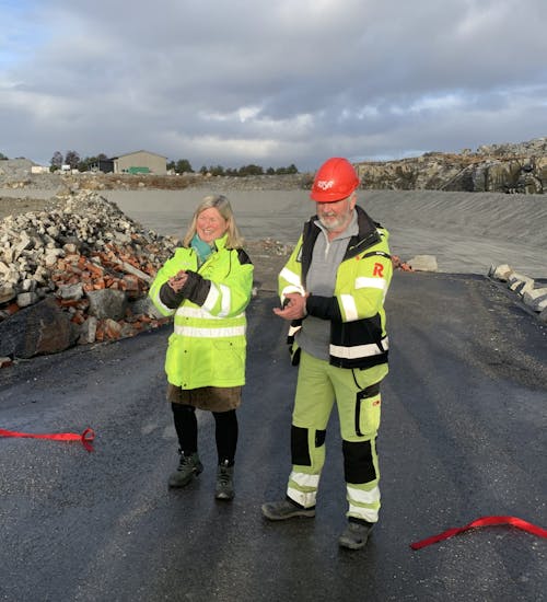Bilde av Gro Staveland i HIM og Øyvind Stange fra Risa. De står ved en avklippet rød snor foran det nye deponiet.