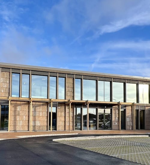 HIM sitt nye bygg sett fra utsiden. Det er blå himmel og sol.