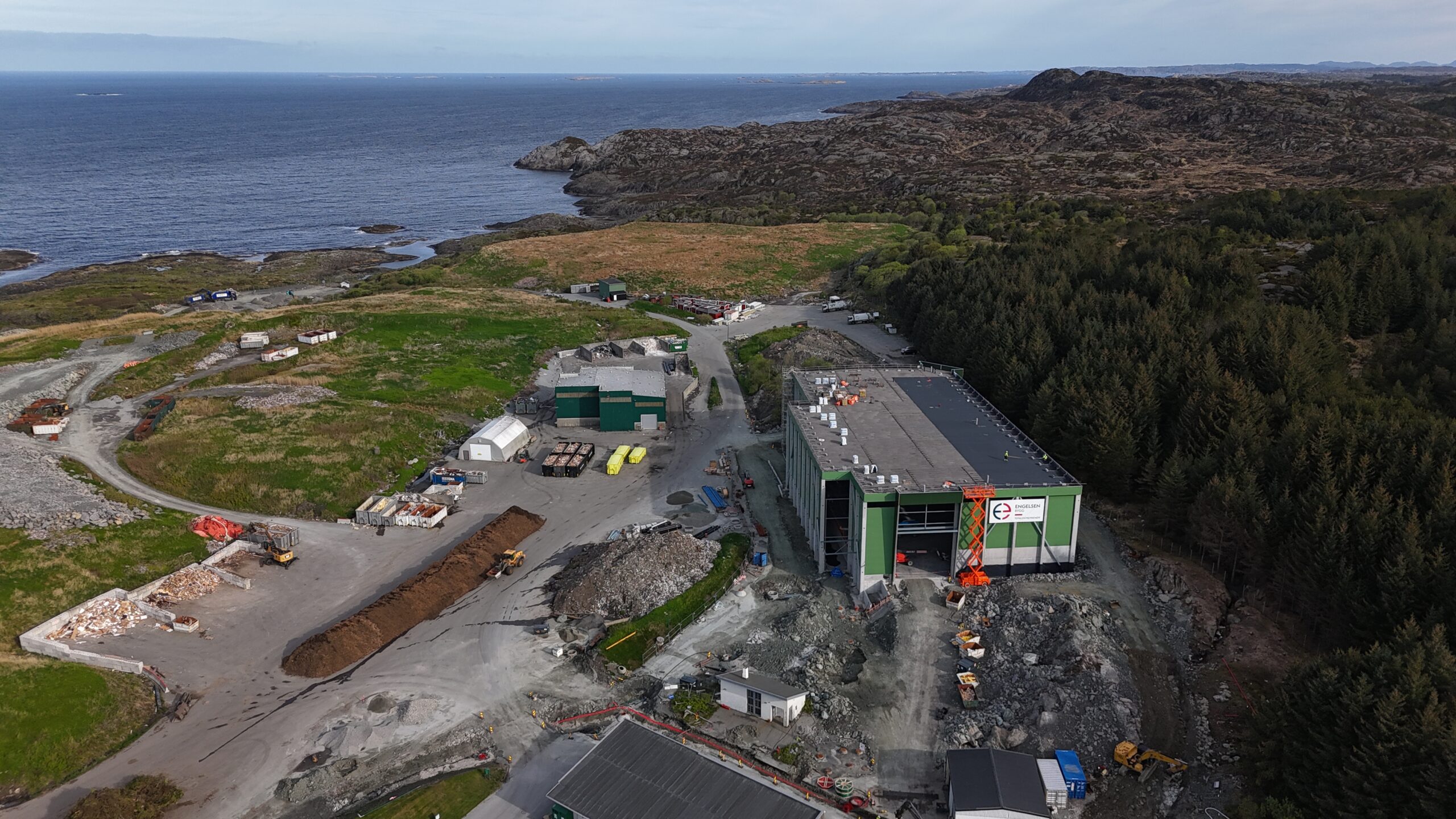 Sorteringshallen på Årabrot fotografert med drone. Hallen er grønn, og i bakgrunnen viser landskap og hav.